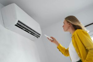 kobieta włączająca klimatyzację